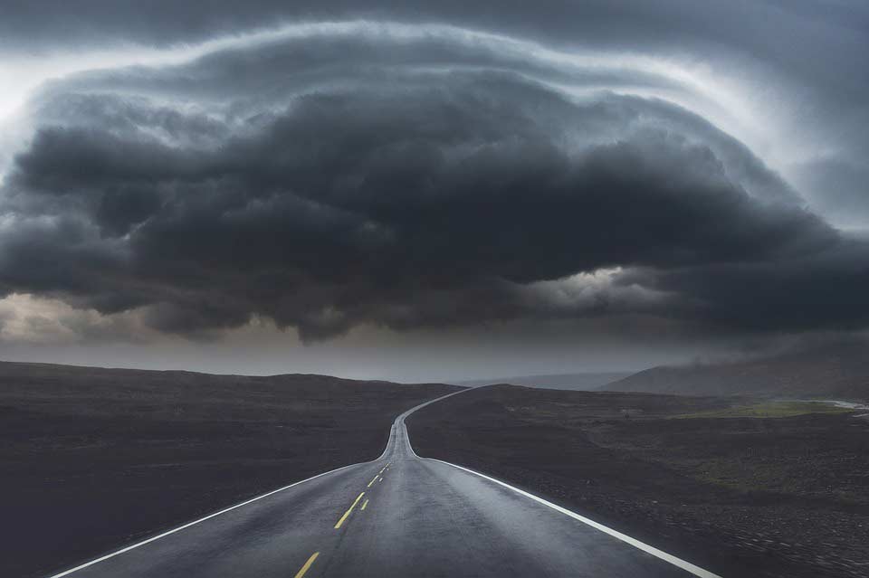 road leading to dark storm